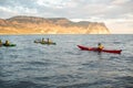 Kayaks. Canoeing in the sea near the island with mountains. People kayaking in the ocean Royalty Free Stock Photo