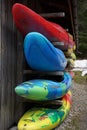 Kayaks and canoes stored and piled in racks in front view.