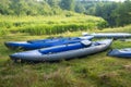 Kayaks for rafting along the river on the river bank. Boats or canoes on the river shore. Royalty Free Stock Photo