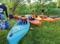Kayaks on the river shore, tourists are preparing for rafting on canoe