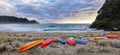 Kayaks scattered on a sandy dune at Onemana beach, Coromandel, New Zealand