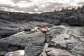 Kayaks stand moored on a rocky shore, in the background there is Royalty Free Stock Photo