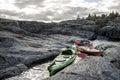 Kayaks stand moored on a rocky shore, in the background there is Royalty Free Stock Photo