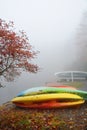 Kayaks stock on dock on the foggy lake.Girl enjoying beautiful autumn forest on foggy morning. Royalty Free Stock Photo