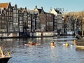 Kayaks on Amstel river in central Amsterdam and a tour boat passing by. Royalty Free Stock Photo