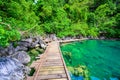 Kayangan Lake - Blue crystal water in paradise lagoon - walkway on wooden pier in tropical scenery - Coron island, Palawan, Royalty Free Stock Photo