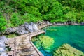 Kayangan Lake - Blue crystal water in paradise lagoon - walkway on wooden pier in tropical scenery - Coron island, Palawan, Royalty Free Stock Photo