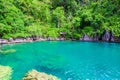 Kayangan Lake - Blue crystal water in paradise lagoon - walkway on wooden pier in tropical scenery - Coron island, Palawan, Royalty Free Stock Photo