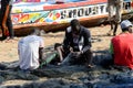 Unidentified Senegalese man sews a fishing net on the coast of