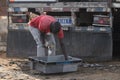 Unidentified Senegalese man takes fish from the basin on the co