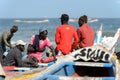 Unidentified Senegalese people sit on the boats on the coast of