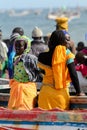 Unidentified Senegalese women stand near the boat on the coast