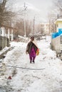 KAZA, SPTI, INDIA - Dec 14, 2019: An Old Lady walking in the middle of a Snow talking over the Phone Royalty Free Stock Photo