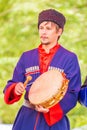 Kazak musician holds a tambourine in his hands and beats him with a beater