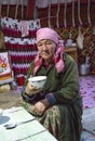 Kazak woman in Mongolia, drinking tea at her home yurt