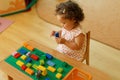 Kazakh curly girl playing in kids development center