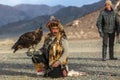 Kazakh Eagle Hunter Berkutchi with horse while hunting to the hare with a golden eagles on his arms Royalty Free Stock Photo