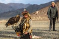 Kazakh Eagle Hunter Berkutchi with horse while hunting to the hare with a golden eagles on his arms Royalty Free Stock Photo
