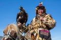 Kazakh Eagle Hunter traditional clothing, while hunting to the hare holding a golden eagle on his arm Royalty Free Stock Photo