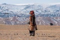 Kazakh Mongolian man dressed with traditional outfit training the golden eagle to catch a fox pray Royalty Free Stock Photo