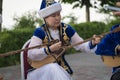 Kazakh woman in blue costume playing dombra Kazakh musical instrument