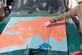 Kazakhstan, Kostanay, 19-06-19, Map of Eurasia on the hood of an old car. The hand of the guy indicates the path of movement of