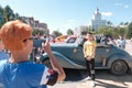 Kazakhstan, Kostanay, 19-06-19, The Greatest Motoring Adventure - Peking to Paris. Red-haired girl takes pictures of an Asian man
