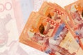 5000 Kazakhstani tenge bills lies in stack on background of big semi-transparent banknote. Abstract presentation of national