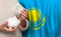 Kazakhstani woman with money bank on the background of Kazakhstan flag. Dotations, pension fund, poverty