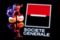 Metal bull stands on buy-sell dices on background of Societe Generale bank logo