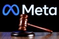 Gavel on table against the background of Meta company logo