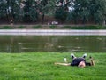 Kazan, Russia. 20.08.2021. A man is lying on the lawn near the lake with a phone