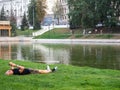 Kazan, Russia. 20.08.2021 . A man is lying on the lawn near the lake with a phone