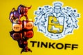 Metal bull stands on buy-sell dices on background of Tinkoff bank logo