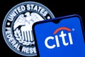 Smartphone with Citigroup logo on background of Federal Reserve symbol