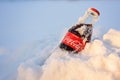 Kazan, Russia, March, 17, 2018: Original glass bottle of Coca-Cola frozen stuck in the snow in bright sunset