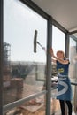 KAZAN, RUSSIA - MAY 8, 2019: cleaning company. The girl from the cleaning company washes the window. Royalty Free Stock Photo