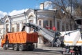 Asphalt removing machine and orange tipper truck on street Royalty Free Stock Photo