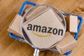 Modified photo of Amazon logo on a box under magnifying glass in the shopping cart Royalty Free Stock Photo