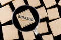 Modified photo of Amazon logo on a box under a magnifying glass surrounded by parcels