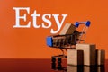 Shopping cart with parcels on the background of the Etsy logo