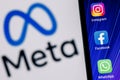 Facebook changes its name to Meta. Smartphone with Facebook, Whatsapp and Instagram app icon on the background of Meta logo