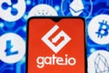 Gate.io logo on smartphone screen against the background of the main cryptocurrencies