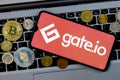 A smartphone with the Gate.io logo metal coins, bitcoin, ethereum on a laptop keyboard