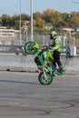 A biker rides on the back wheel of a bike