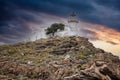 Kea island, Greece. Lighthhouse Tamelos on a rocky cliff, cloudy sky background Royalty Free Stock Photo