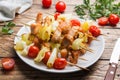 Kebab chicken, zucchini and tomatoes on skewers in a plate. Wooden table Royalty Free Stock Photo