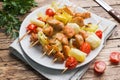 Kebab chicken, zucchini and tomatoes on skewers in a plate. Wooden table Royalty Free Stock Photo