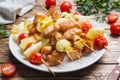 Kebab chicken, zucchini and tomatoes on skewers in a plate. Wooden table Royalty Free Stock Photo