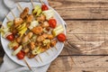 Kebab chicken, zucchini and tomatoes on skewers in a plate. Wooden table. Copy space Royalty Free Stock Photo